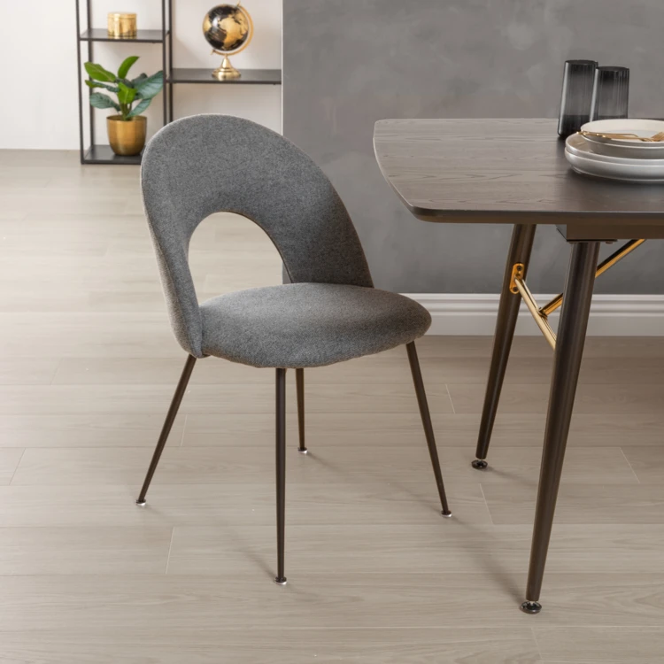 Silla de tela con respaldo calado y patas de metal