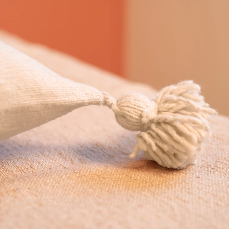Housse de coussin en laine à pompons