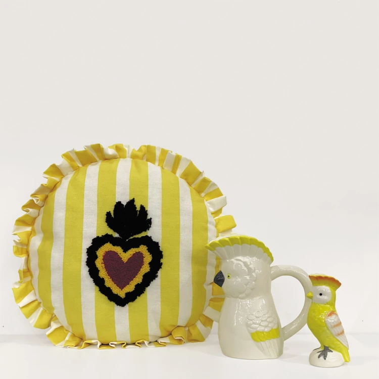 Coussin rond à rayures avec motif cœur brodé