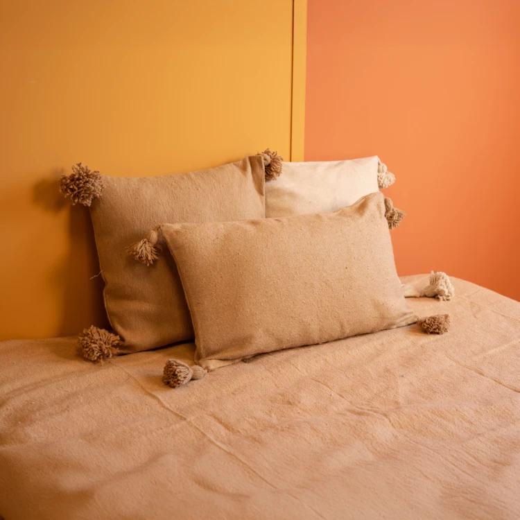 Housse de coussin en laine à pompons